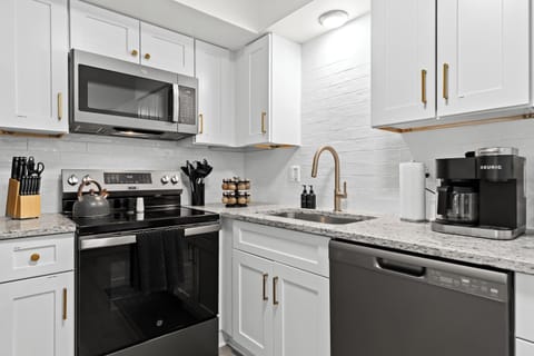 Sleek kitchen featuring stainless steel appliances, granite countertops, and a Keurig coffee maker.