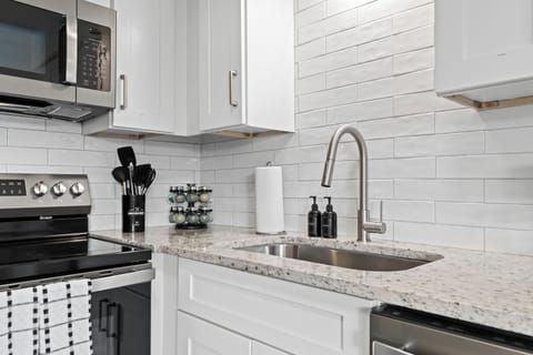 Beautifully tiled backsplash and deep sink with modern matte black fixtures.