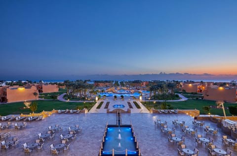 Unwind at dusk as lights shimmer across the courtyard pools.
