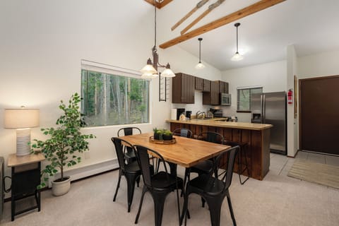 Your open-concept kitchen and dining area features exposed beams, modern appliances, and forest views for memorable meals together.