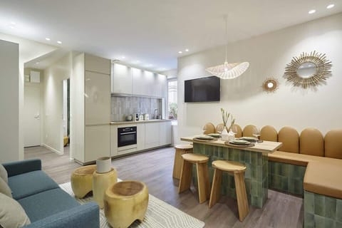 Salon avec espace repas, cuisine et canapé lit