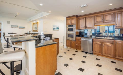 Prepare meals in the spacious kitchen with elegant wooden cabinetry, sleek countertops, and ample seating for socializing
