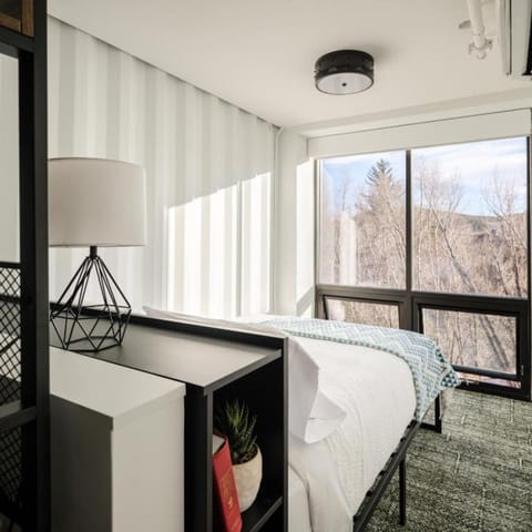 Wake up to serene forest views beside crisp linens.