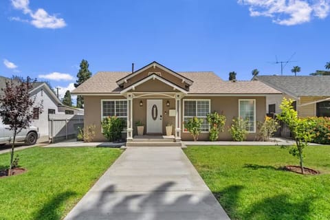 Welcoming front view with porch, fresh lawn, and sunny curb appeal all around.