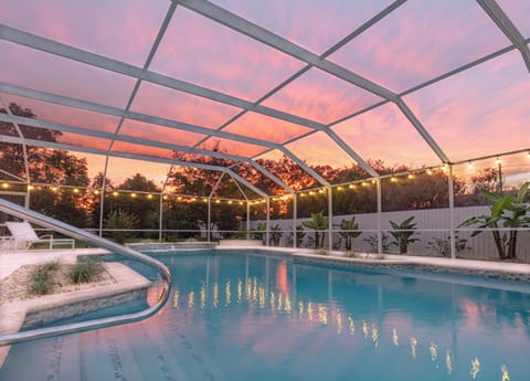 Unwind in the screened-in pool as sunset colors glow overhead & string lights set the mood for peaceful evening swims.