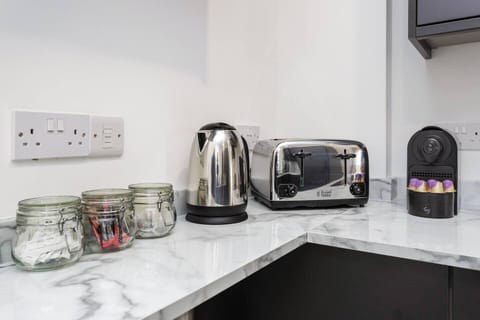 Black cabinets, sharp lines, and your morning brew on tap – this kitchen means business.
