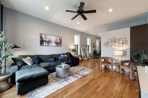 Bright open living area w/ comfy seating, ceiling fan, and warm wood floors made for relaxing together