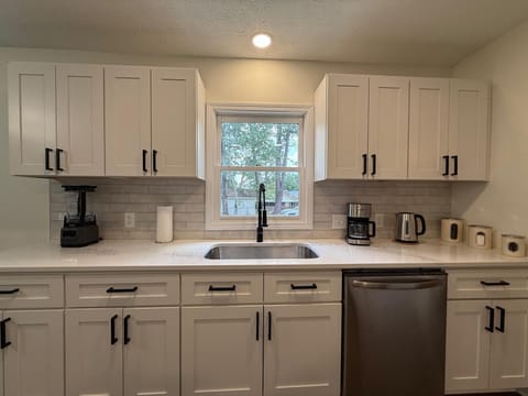 Modern, fully equipped kitchen with sleek cabinets and bright lighting.