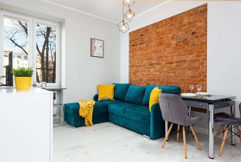 The vibrant living area adorned with elegant green and yellow hues featuring a double sofa bed.