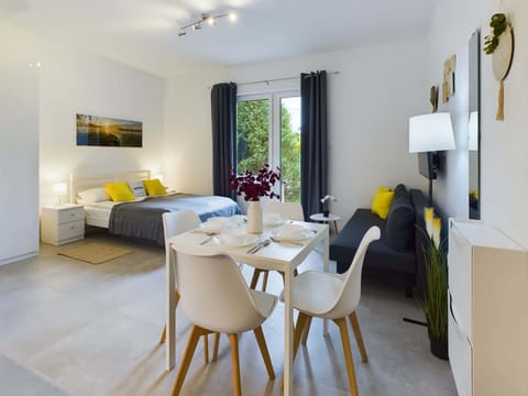 Spacious living room with dining table, double bed and sofa bed.