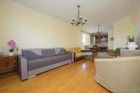 A cozy living room space with a sofa and coffee table, perfect for relaxing or entertaining. Large windows let in plenty of natural light.