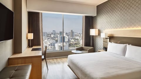Sink into a king bed with sparkling city lights outside.