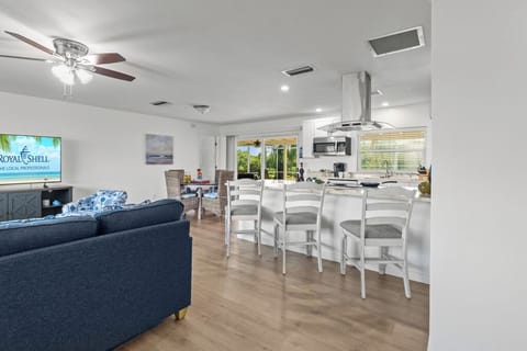 Open-concept living area seamlessly connects the coastal-style living room, modern kitchen, and cozy breakfast nook