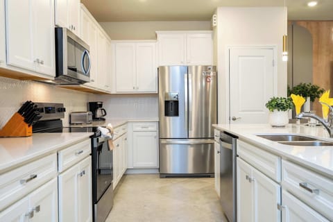 Whip up delicious meals in this bright, modern kitchen, fully equipped with sleek stainless steel appliances and ample counter space.