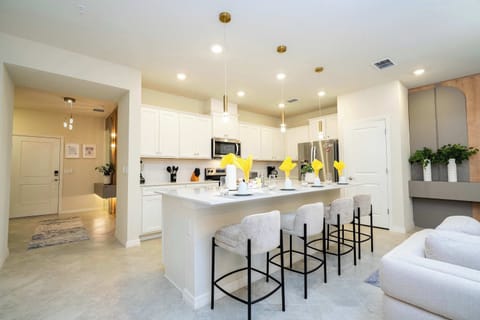 Gather around the spacious kitchen island in this bright, modern space-perfect for casual meals and friendly conversation under stylish pendant lights!