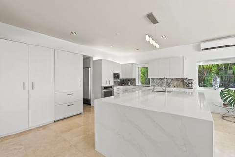 Entertain with ease in the gourmet kitchen—featuring premium appliances, marble counters, and an expansive island ideal for prepping or gathering.