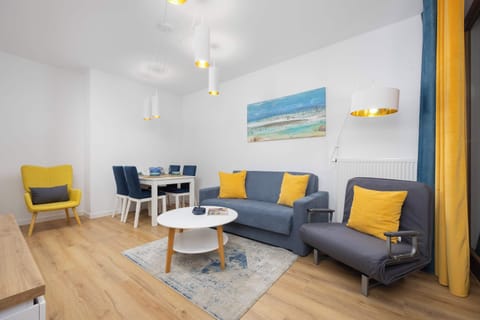 Blue and yellow bedroom with air conditioning, double sofa bed, and large flat-screen television.