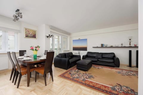 Bright windows and light walls illuminate the space, creating a perfect spot for shared meals and relaxing with a movie.
