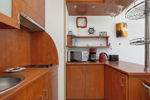 Kitchenette with brown cabinets, equipped with modern appliances.