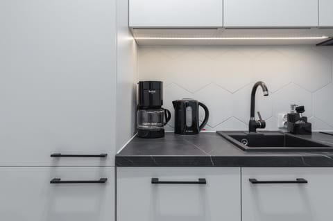 A minimalist and fully equipped kitchen, with white cabinets and sleek appliances, ready for you to prepare your favorite meals.