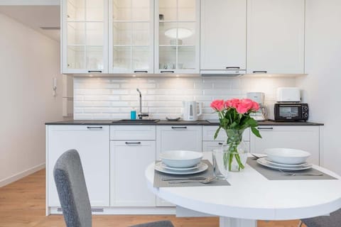 A dining space with a round white table set with plates and cutlery, surrounded by comfortable chairs.