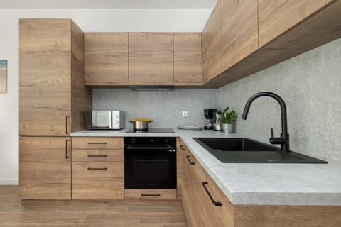 Wooden cabinetry and modern appliances in the kitchen encourage culinary creativity.