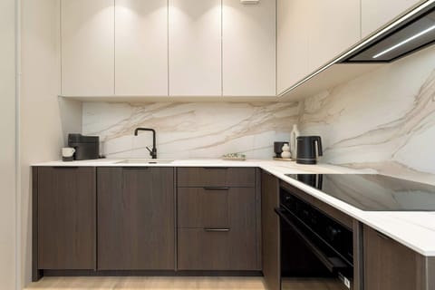 A modern kitchenette with sleek cabinets and built-in appliances, ideal for everyday cooking.