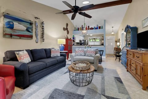 The vaulted, open main living space includes living room, dining area and kitchen, furnished in comfortable, easy furnishings.