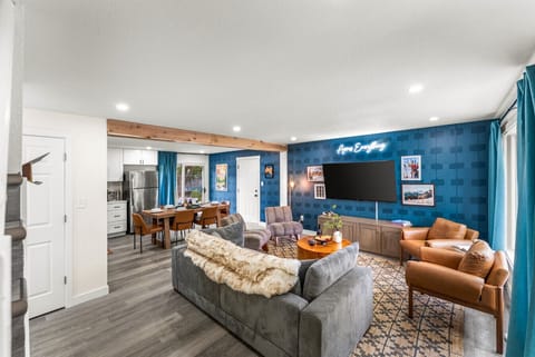 Cozy open-plan living room with plush sofa, smart TV, and natural light