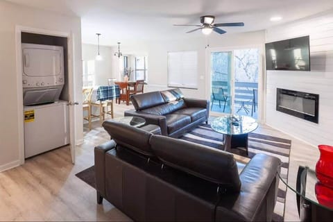 This open-concept living space features leather seating, a Smart TV, electric fireplace, and private balcony access. Enjoy added convenience with in-unit laundry and a dining area just steps away—perfect for extended stays or easy everyday living.