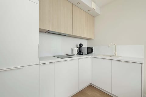 Bright and modern kitchen featuring an induction cooktop, built-in oven, and plenty of counter space. A perfect setup for preparing meals with ease.
