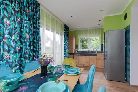A full view of the dining and kitchen area with natural light highlighting the colorful details.

