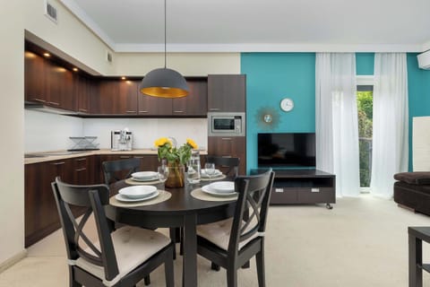 A stylish living and dining area with contemporary furnishings and a turquoise accent wall. Perfect for shared meals and relaxing evenings.