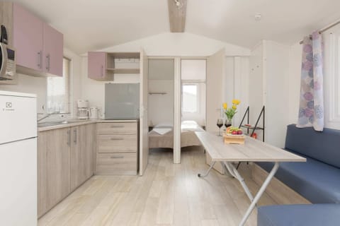 A cozy seating arrangement with a sofa, coffee table, and a view of the open-plan kitchen.