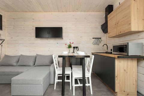 Living and kitchen view from another angle showing a consistent modern and wooden design.