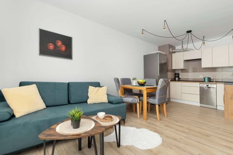 A cozy living room space with a stylish sofa set and two round coffee tables. The area is well-lit and decorated with minimalist decor.