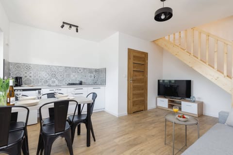 A compact yet fully equipped kitchen with white cabinetry and intricate patterned tiles on the backsplash. The space is designed for efficient meal preparation.