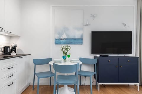 A fully equipped kitchen with white cabinetry, a tiled backsplash, and modern appliances.