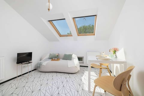 Bright living area with a white sofa, table, and skylights.