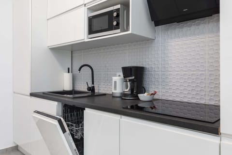 A compact yet functional kitchen with all necessary appliances, blending style and practicality.
