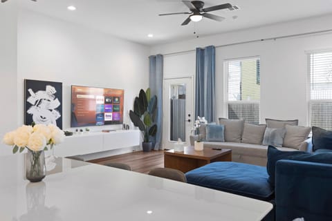 Living Room Retreat: Embrace relaxation with smart TV and vibrant decor amidst natural light!