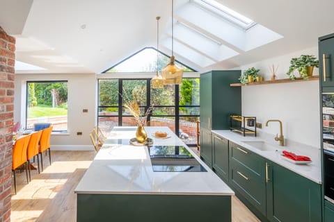 Ground floor: Kitchen/ dining room with electric oven and induction hob, microwave, dishwasher, fridge-freezer and dining table with seating for eight and french doors leading to an enclosed garden