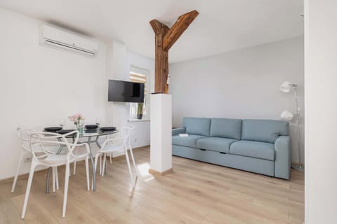 Stylish and elegant living room with dining table and chairs, television and comfortable double sofa bed.