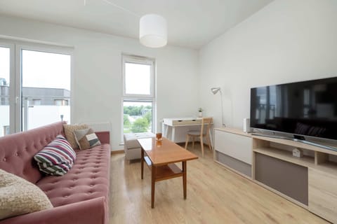 A spacious living room with a comfortable sofa and a large TV invites you to relax together after a day full of experiences.
