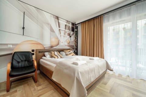 The spacious living room, decorated in tones of wood, orange, gray and beige, features a comfortable double bed for a comfortable rest after a busy day.