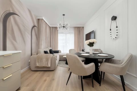 Modern living area with a comfortable sofa, an elegant coffee table, a flat-screen TV and dining area.