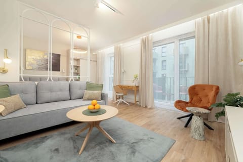A cozy living room with soft lighting, a gray sofa, and a round wooden coffee table that adds warmth to the space.