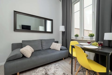 Comfortable sofa located in a bright living room with a mirror and a dining area.