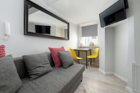Comfortable sofa located in a bright living room with a mirror and a dining area.