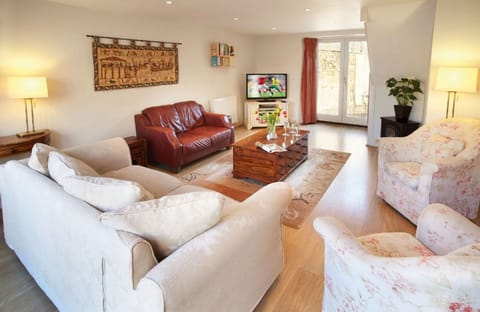 Dual aspect sitting room with comfy seating and french doors leading to the courtyard